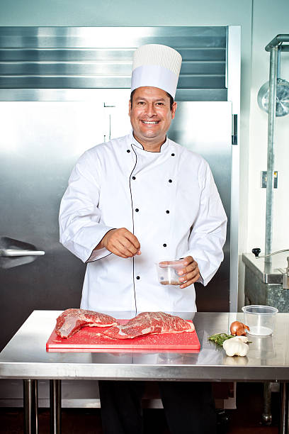 istock smiling chef sprinkling steak with seasoning 186886202