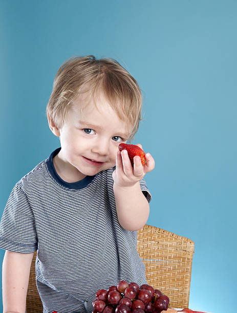 istock Young child holding strawberry 186886783