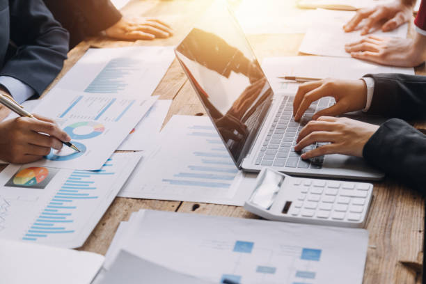 istock Financial analysts analyze business financial reports on a digital tablet planning investment project during a discussion at a meeting of corporate showing the results of their successful teamwork. 1868911351