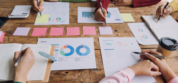 istock Financial analysts analyze business financial reports on a digital tablet planning investment project during a discussion at a meeting of corporate showing the results of their successful teamwork. 1868911358