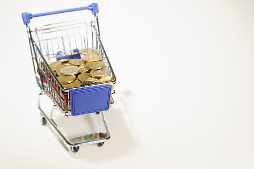 shopping cart full of euro coins ,isolated on white background