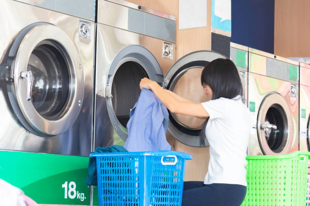 istock Young woman doing the laundry in a launderette. 1869091710