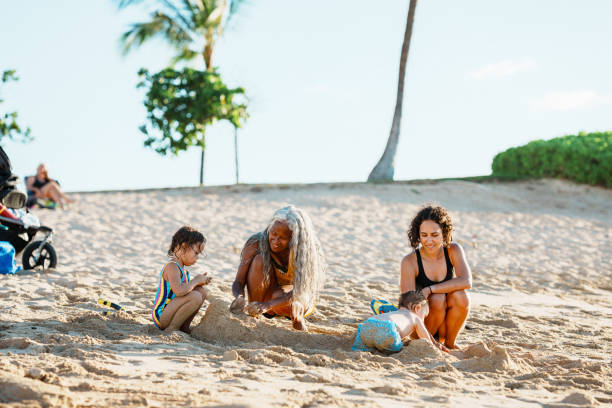 istock Multi-generation family plays in the sand at the beach 1869117357