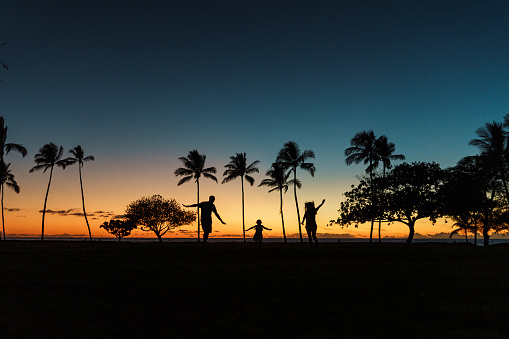 Senior couple dancing at the beach with their granddaugther