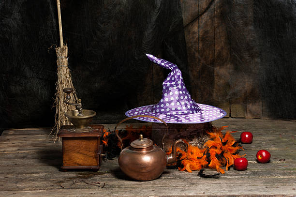 Halloween still live with hat, coffee mill, broom and cauldron