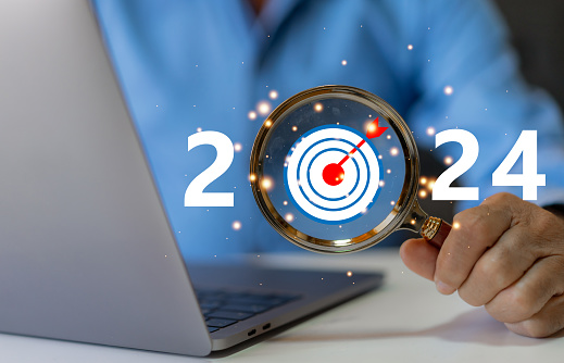 Human with magnifier 2024 new year wording for marketing and business planing, action plan for success growth, trend on 2024 and new ideas, startup, technology, new business plan and development