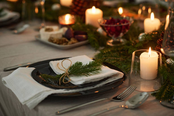 istock Plate on Candlelit Festive Table Decorated with Christmas Tree Branch 1869130158