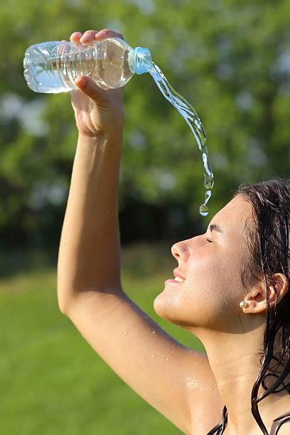 istock Beautiful woman throwing herself water from bottle 186913396