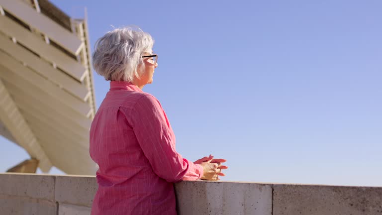 Senior woman walking to a viewpoint and enjoying sun