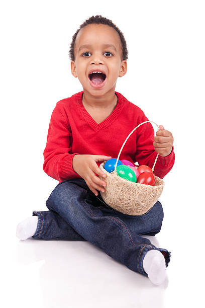 Cute little boy collecting eggs in an Easter egg hunt