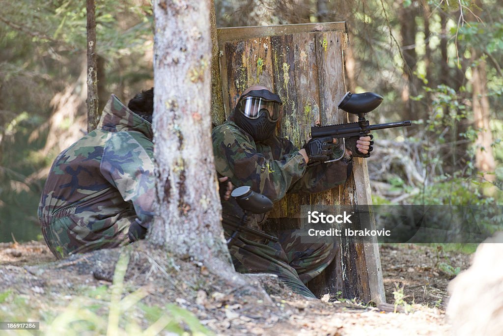 Paintball jogadores esconder atrás de árvore - Foto de stock de Abrigando-se royalty-free