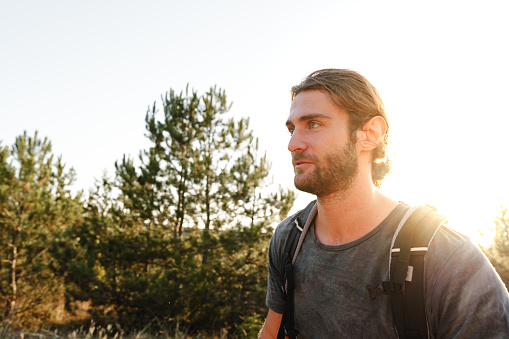 Portrait of hiker man with backpack trekking in the mountains close up