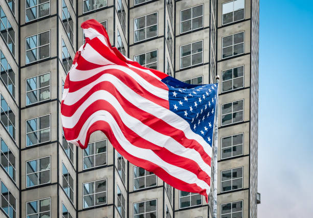 istock American flag in front of skyscraper. 1869189048