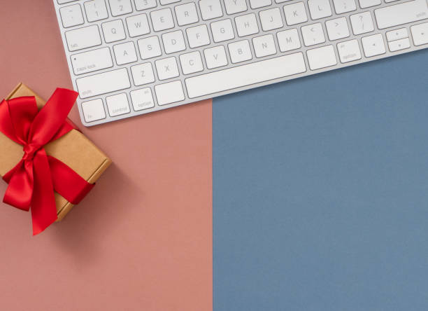 istock Christmas composition. Christmas gift and computer keyboard on blue and pink background. 1869190653