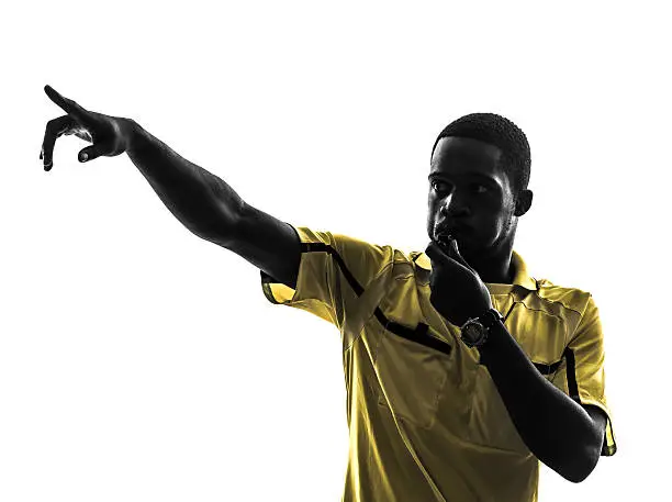 one african man referee whistling pointing in silhouette on white background