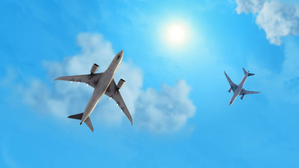 istock Low angle view flying aeroplanes with sky and sun 1869218266