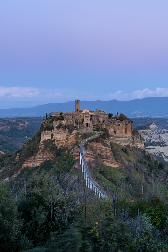 Bagnoregio, Italy - 17 November, 2023: vertical view of the old fortified hilltop village of Civita di Bagnoregio in central Italy at sunset