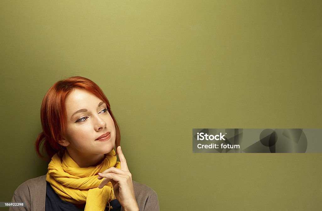 Young caucasian woman thinking Young caucasian woman thinking near the green wall Adult Stock Photo