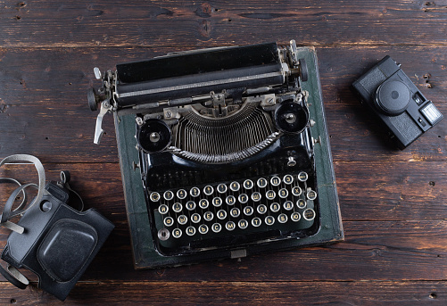 old tipywriter with old camera on wooden background