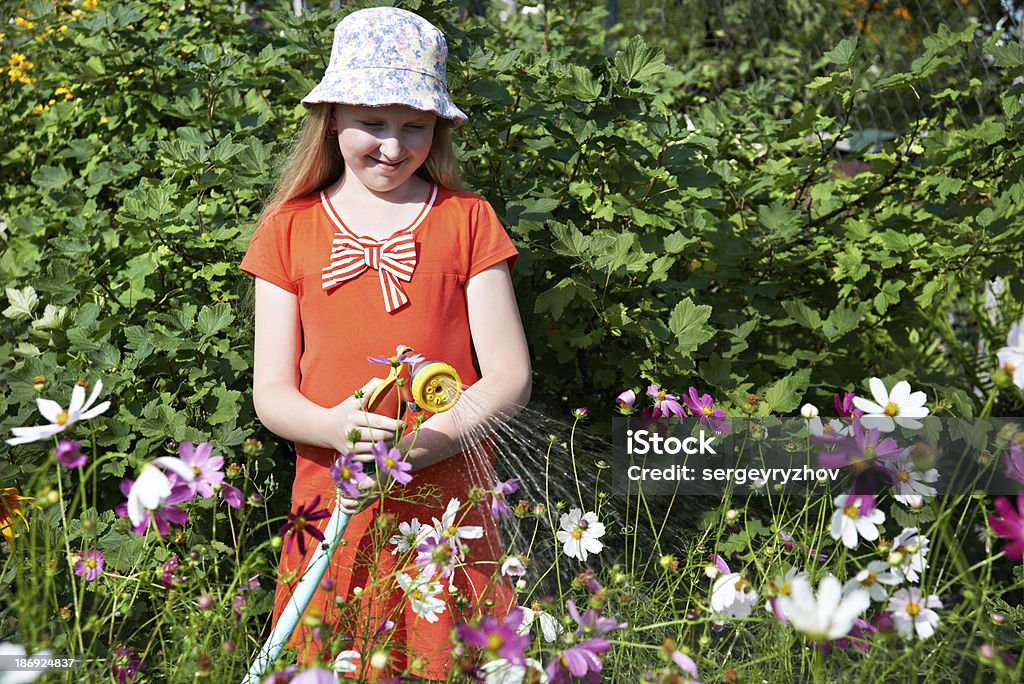 Petite fille en train d'arroser des fleurs - Photo de Arroser libre de droits