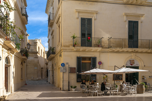 Lecce, Italy - 30 November, 2023: people enjoying drinks in a street café in the Baroque Old Town of Lecce in Apulia