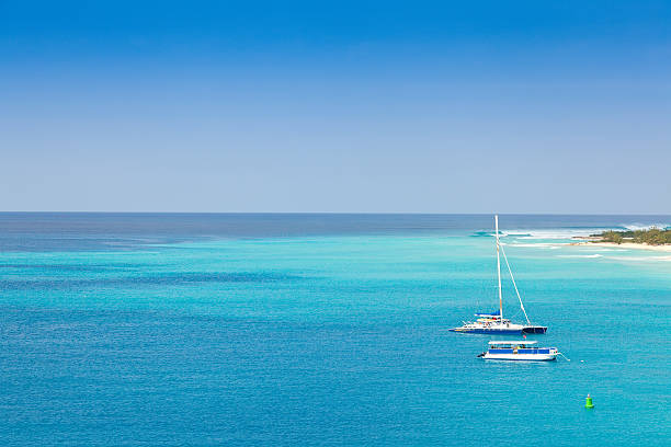 Sailboats in a clear blue ocean at Grand Turk Caribbean waters in the Turks and Caicos Islands turks and caicos islands caicos islands bahamas island stock pictures, royalty-free photos & images