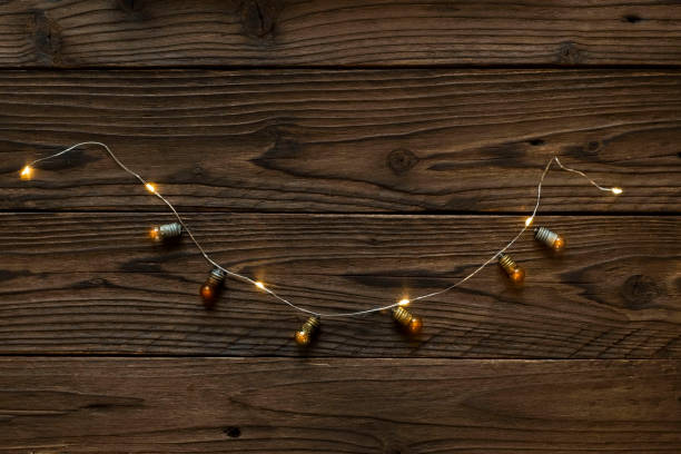 istock christmas lights shining on wooden table 1869250908