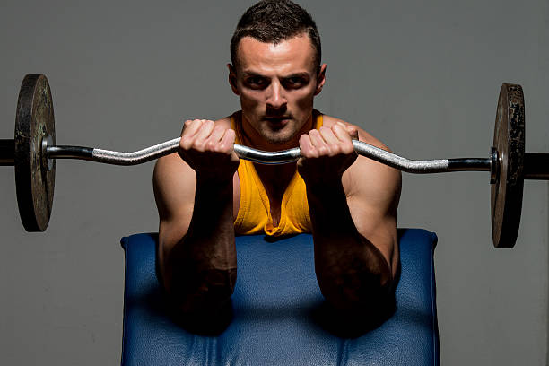istock fitness trainer doing heavy weight exercise for biceps 186925243