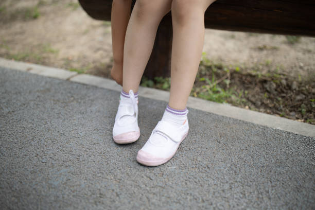 istock Little girl adjusts canvas shoes 1869256667