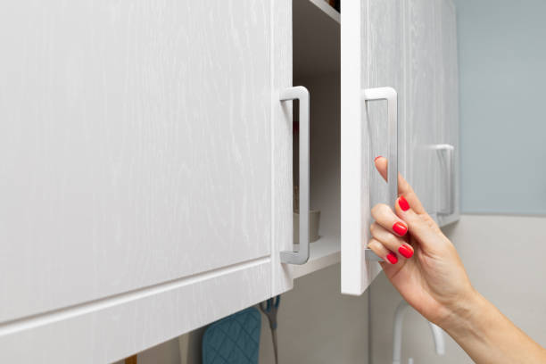 istock female hand opens kitchen cabinet with utensils. 1869257222