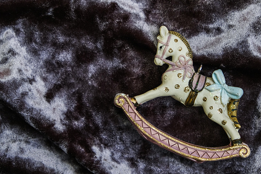 Rocking horse on velvet background. Top view, space for text.
