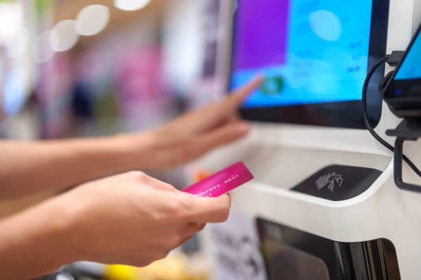 istock A side view captures a woman using a touch screen display to confirm an order or make a payment for products or services at a self-service kiosk machine in a shopping mall. 1869282408