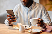 Cropped shot of young African American solopreneur with cup of coffee