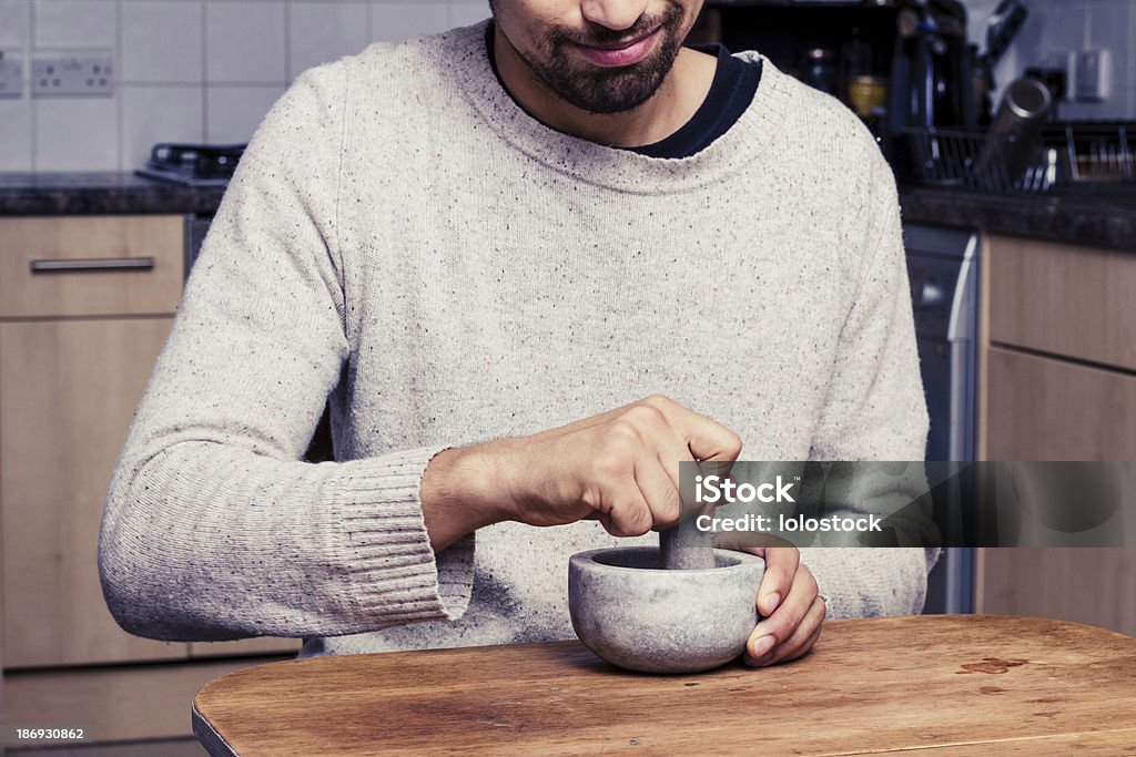 Hombre en la cocina es de esmerilado especias - Foto de stock de Especia libre de derechos