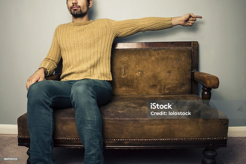 Молодой человек на диван, который прямо - Стоковые фото Help - английское слово роялти-фри