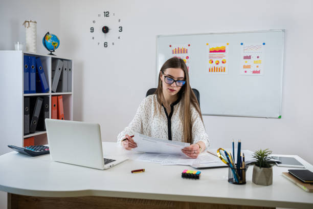 istock business lady works in the office with documents, graphs and financial reports 1869379687