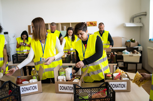 Aid volunteers busy organizing donated groceries at a distribution warehouse