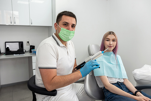 examination of a dentist treating a female patient who came to him with complaints. A woman has a scheduled dental examination at the dentist.