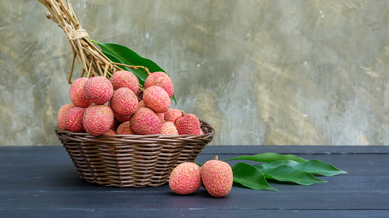 Red lychee on a black wooden table.