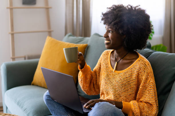 istock Woman enjoying a cup of coffee while working on laptop 1869419120