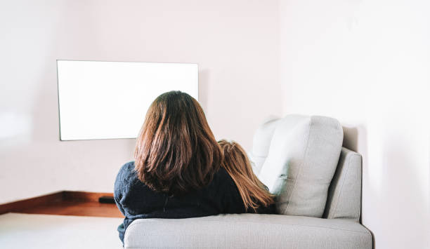 istock rear view on mom and daughter watching tv 1869423952
