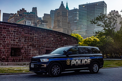 New York, USA; June 1, 2023: NYPD official patrol car, with the Big Apple skyline and Manhattan in the background.