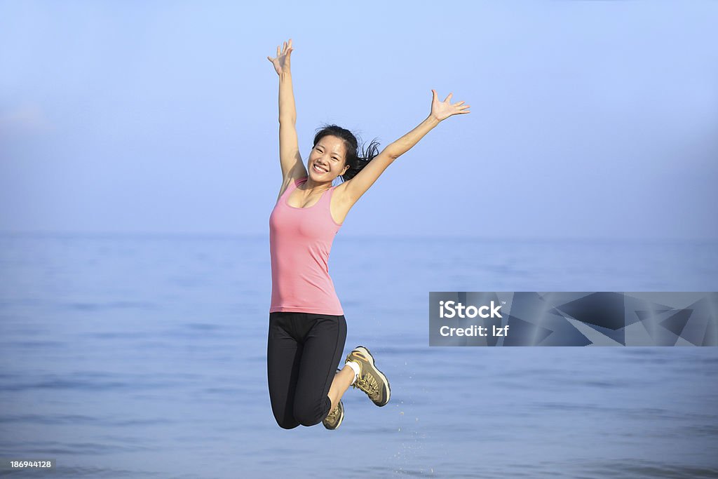 Jeune asiatique femme sautant sur la plage - Photo de Activité libre de droits