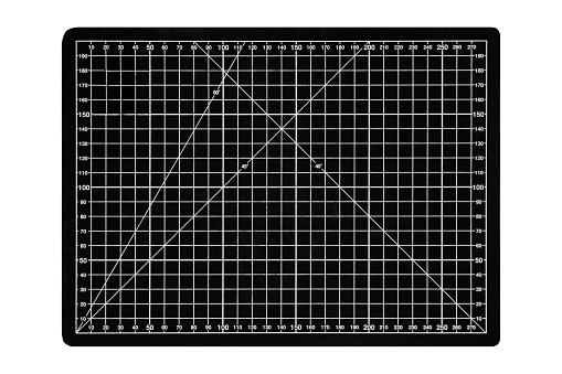 A black cutting mat with a white grid is isolated on a white background.