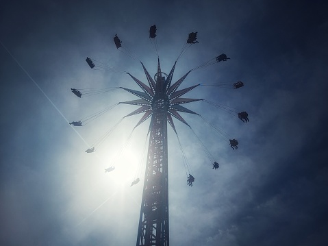 Flying chair in an amusement park attraction with a blue sky