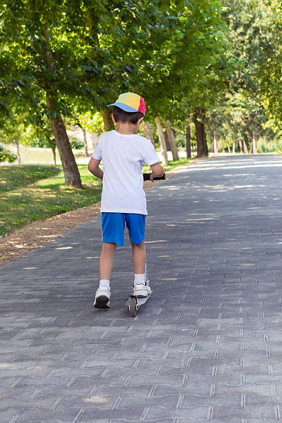 istock Boy with scooter having fun in the park 186946118