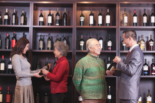 Four People Examining Wine at a Wine Store