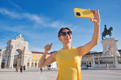 Tourist visiting Lisbon, Portugal - Happy woman taking selfie picture outdoors - Travel, tourism and blogger concept