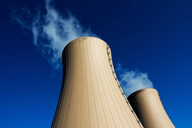 kühlturm der kernkraft-werk vor blauem himmel - kernenergie stock-fotos und bilder