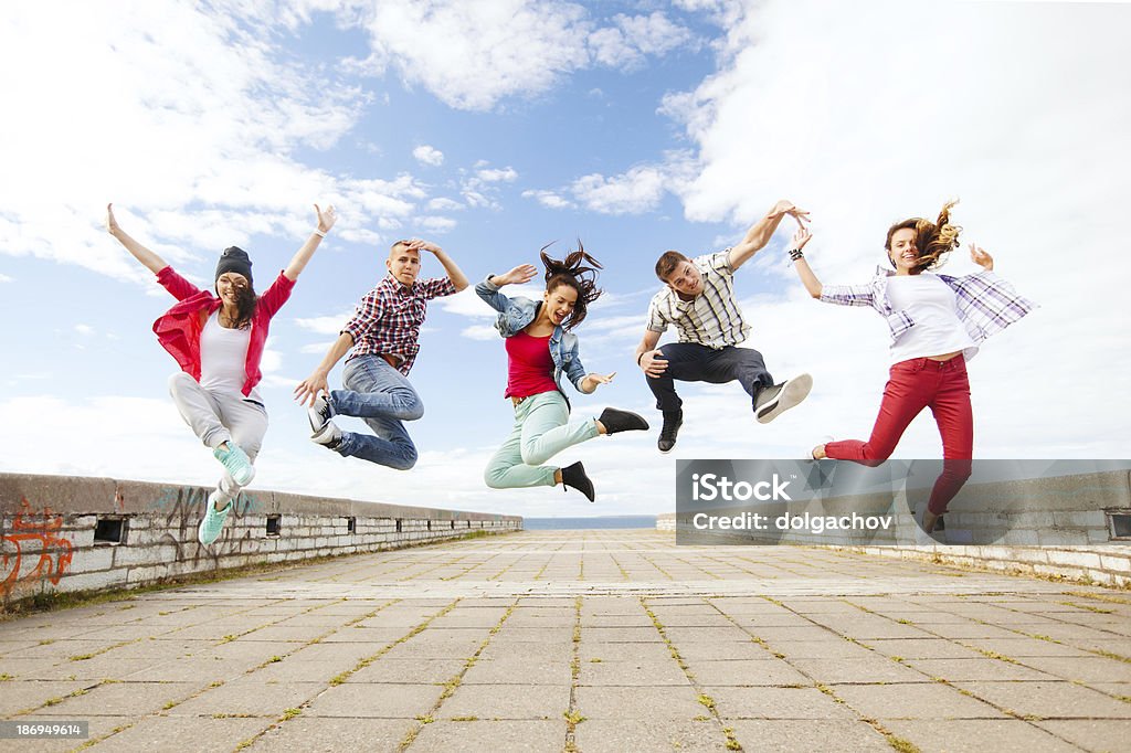 group of teenagers jumping on street summer, sport, dancing and teenage lifestyle concept - group of teenagers jumping on street  Dancing Stock Photo